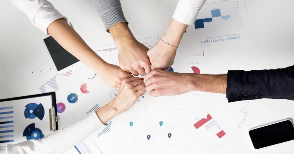 Gerente revisando tablero de equipo con indicadores claros y equipo trabajando en sala moderna