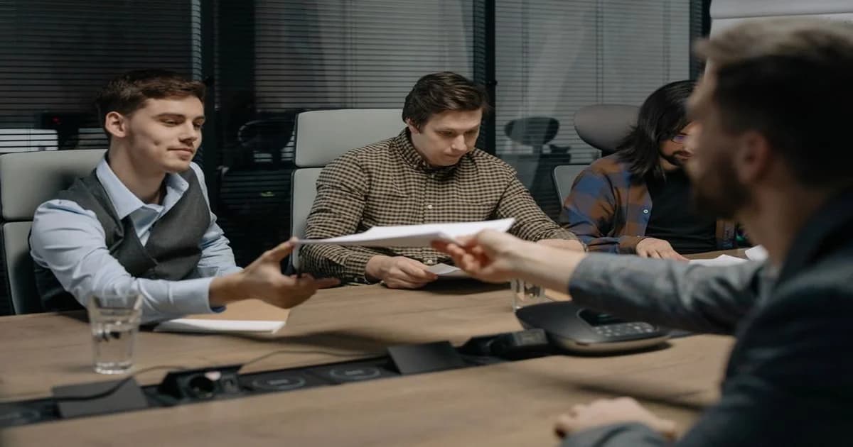 Gerente facilitando conversación entre equipos de distintas áreas en sala de reunión corporativa