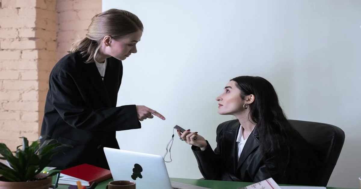 Líder y colaborador en conversación uno a uno en oficina moderna, ambiente de confianza