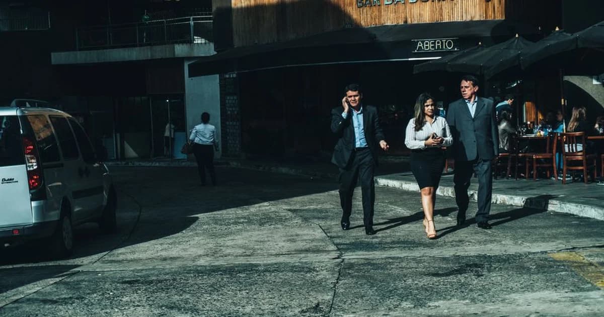 Equipo de trabajo de pie alrededor de una mesa revisando tareas en un tablero visual de gestión