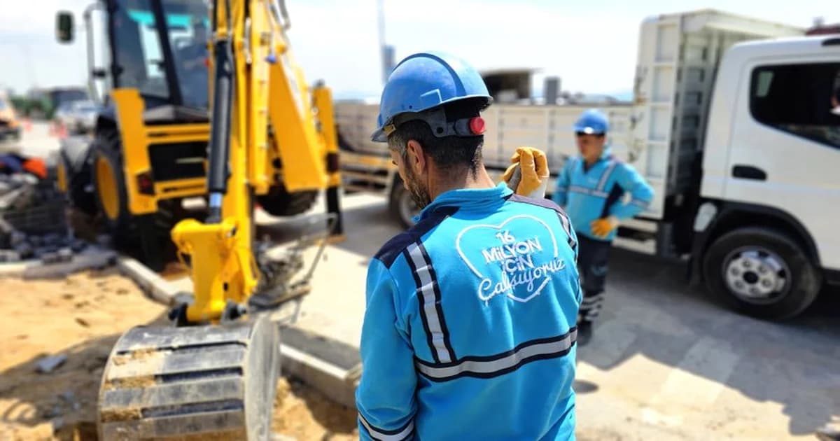 Operario revisando maquinaria en planta industrial con tablero de indicadores de mantenimiento al fondo