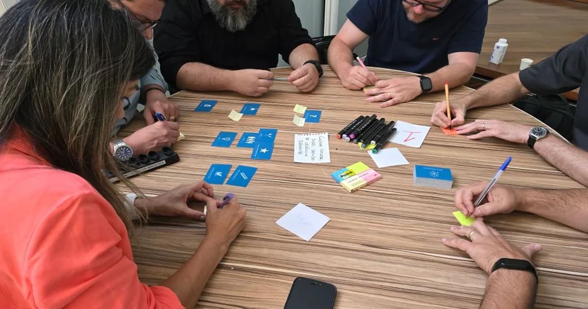 Equipo de trabajo alrededor de una pizarra con diagramas de análisis de causa raíz y pasos del proceso 8D