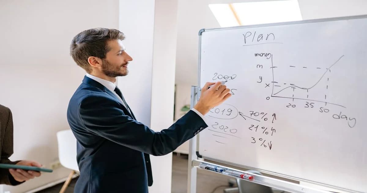 Gerente revisando un tablero de planificación con su equipo en sala de reuniones
