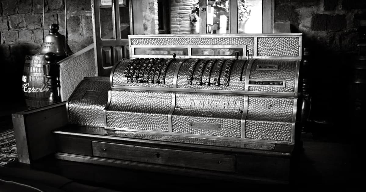 Gerente revisando recibos y billetes sobre un escritorio de oficina con una caja pequeña al lado