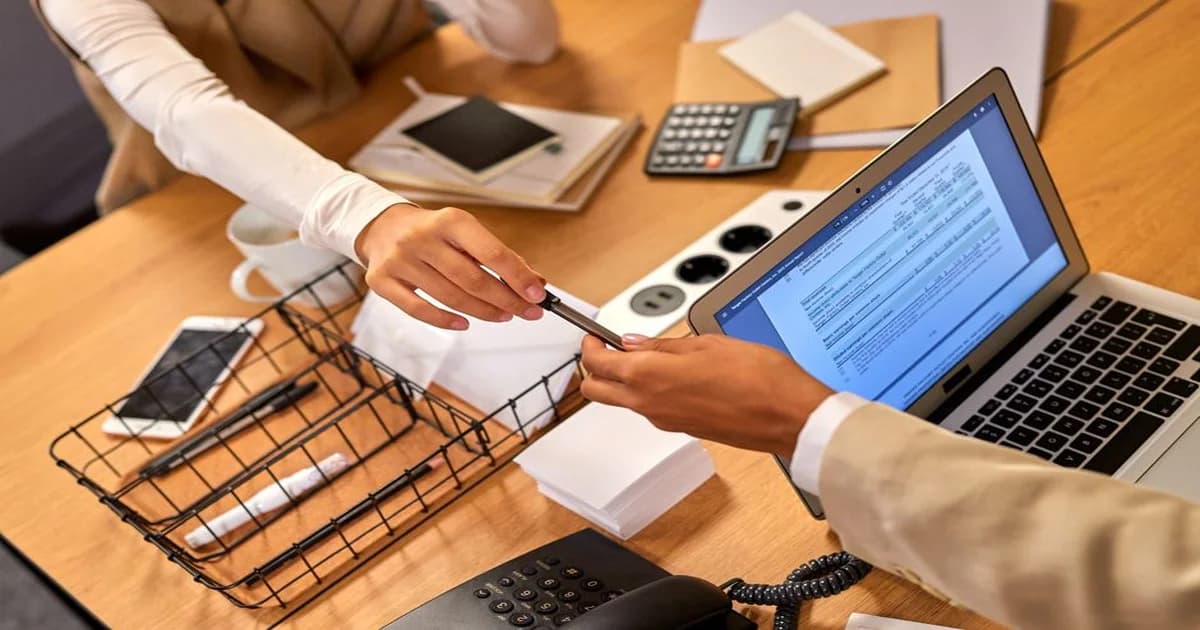 Gerente revisando un estado de cuenta bancario junto a un registro contable en su escritorio