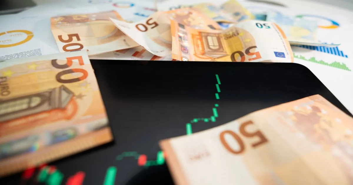 Gerente revisando tabla de amortización en pantalla con gráficas financieras y calculadora sobre escritorio