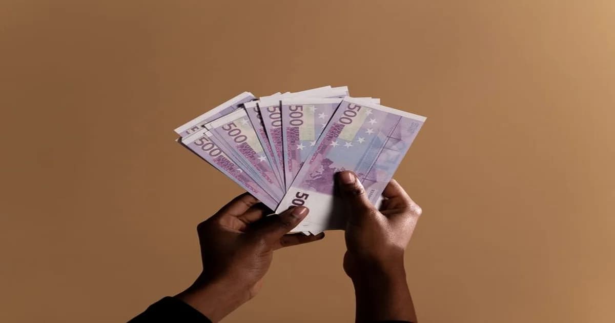 Dos columnas de monedas de distinta altura sobre un escritorio de oficina, simbolizando la brecha salarial entre personas