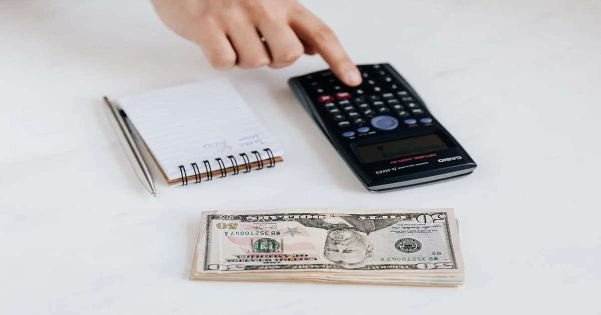 Gerente revisando fórmula del WACC en pizarrón con gráficos financieros y calculadora sobre escritorio