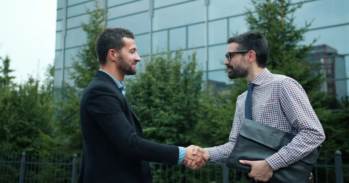 Ilustración de un gerente conversando con un jefe nuevo, apretón de manos y checklist que simboliza previsibilidad