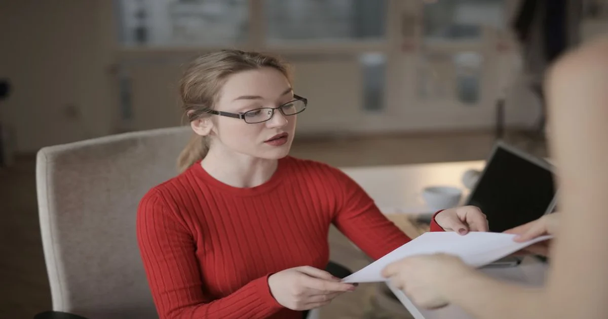 Gerente revisando una carta de oferta laboral impresa sobre un escritorio de oficina