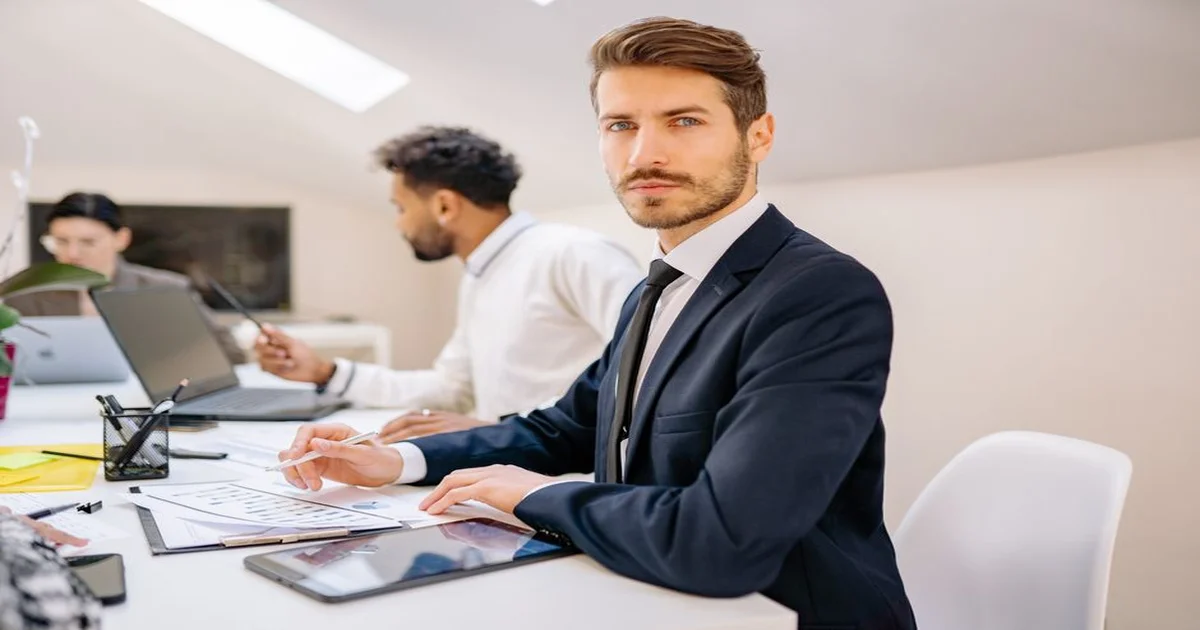 Profesional en sala de reuniones corporativa generando confianza con colegas y su líder