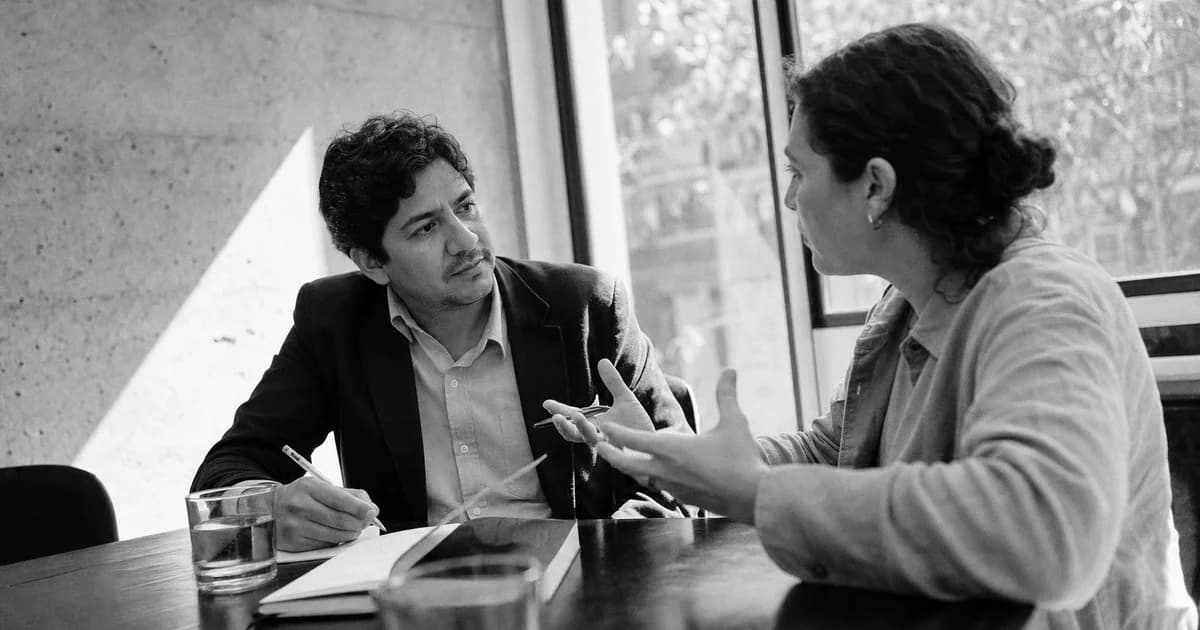 Gerente conversa con un cliente y toma notas