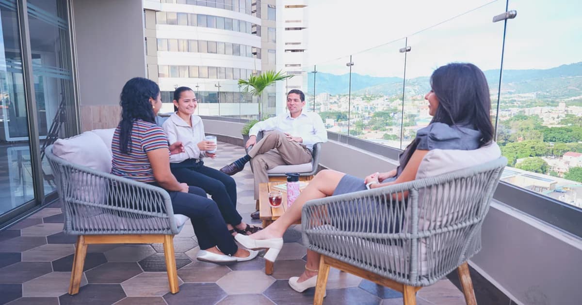 Equipo híbrido diseñando un offsite con pizarras, acuerdos operativos y un tablero de flujo para aumentar la confianza