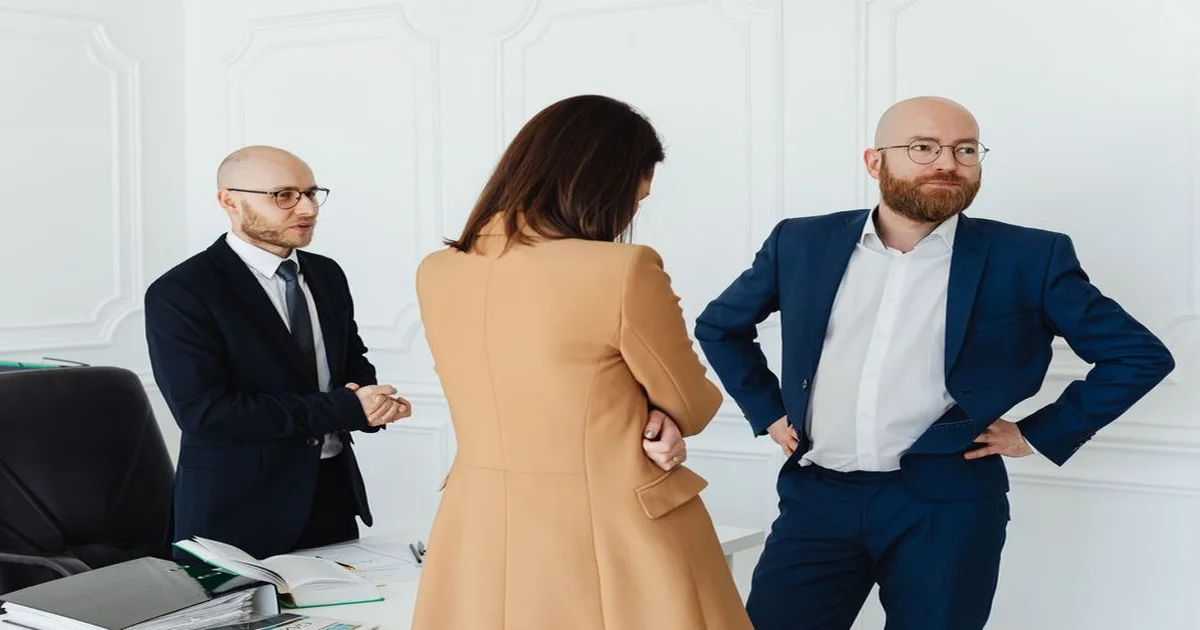 Gerente en reunión difícil con cliente, manteniendo postura profesional y calmada frente a una pantalla con datos