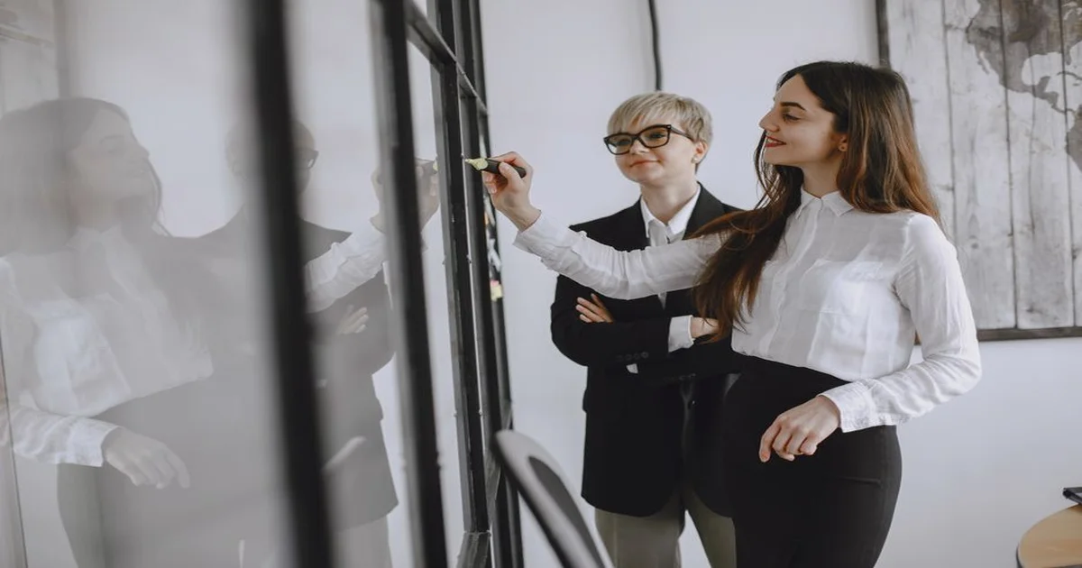 Gerente revisando una matriz de competencias junto a su equipo en una sala de reuniones moderna