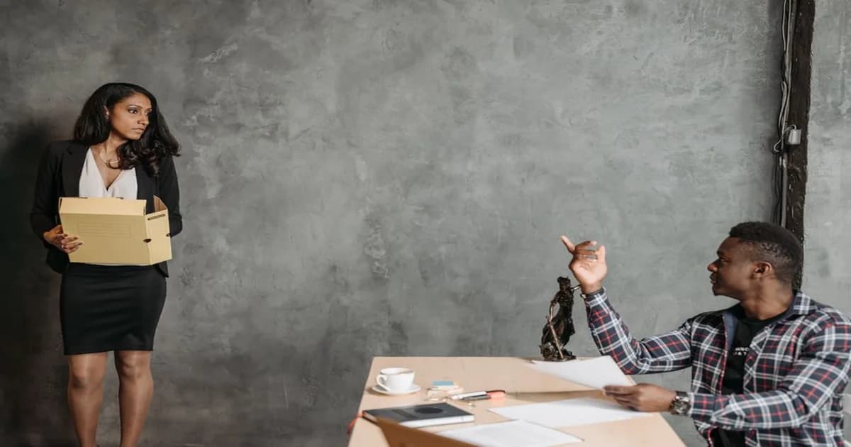 Gerente y colaborador conversando frente a una pizarra con notas sobre decisiones de equipo