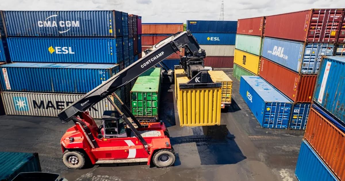 Gerente revisando documentos de importación con mapa global y términos de entrega sobre la mesa