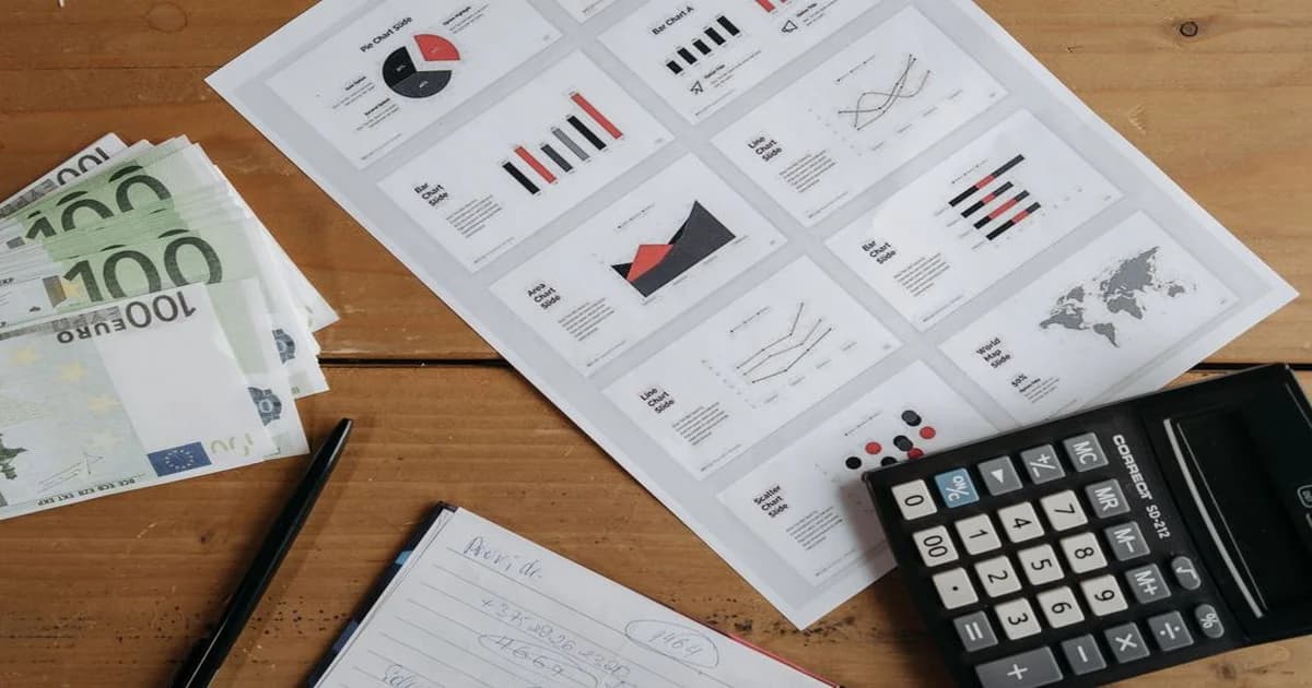 Gerente revisando un cuadro de gastos operativos en una pantalla con gráficas financieras
